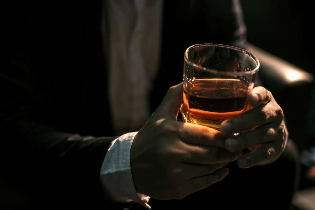 Man holding a glass of whiskey